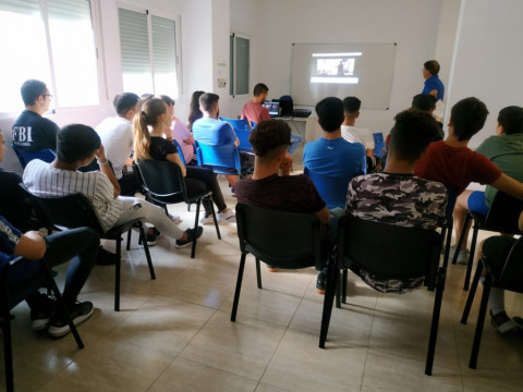 Un grupo de jóvenes atendidos en Azarbe asisten a una charla sobre educación financiera. 2019